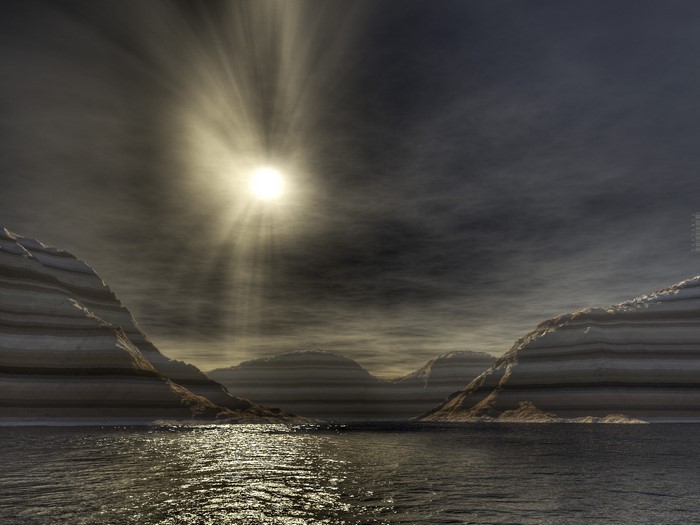 Sunlight beams through clouds over a layered landscape and ocean