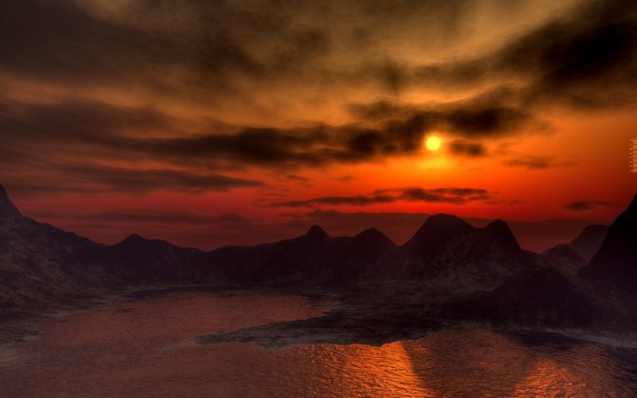 Sunset over a mountainous landscape with water