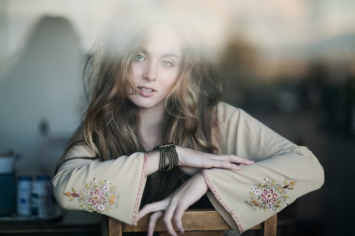 Woman with messy hair and blue eyes wearing a dress
