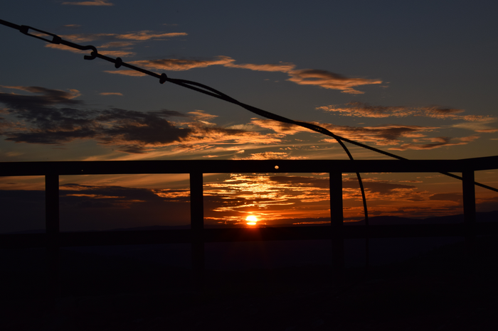 Sunset over the horizon with clouds and cables