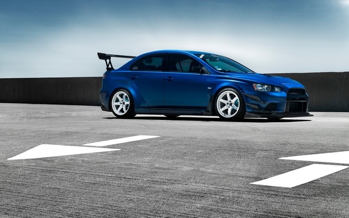 Blue Mitsubishi Lancer Evolution with white wheels