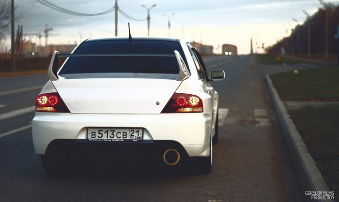 White Mitsubishi Lancer Evolution with spoiler on road