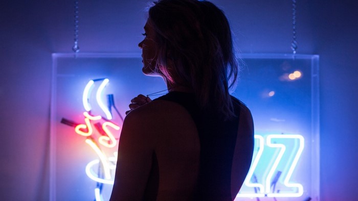 Woman in front of a neon sign