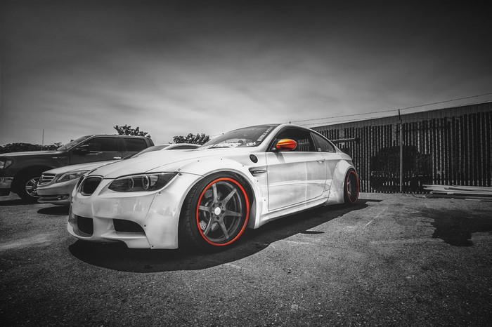 White BMW M3 with orange accents parked outdoors