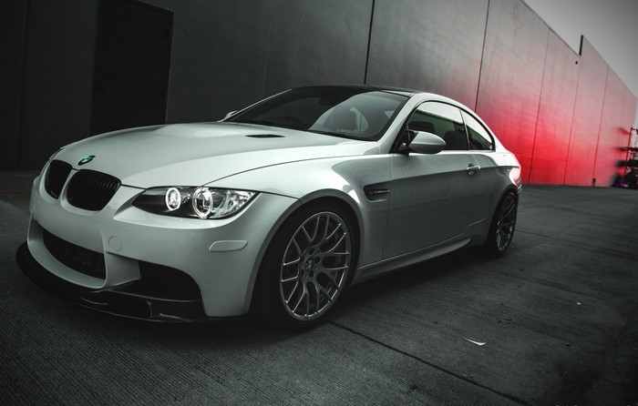 Silver BMW M3 Coupe parked by a red wall