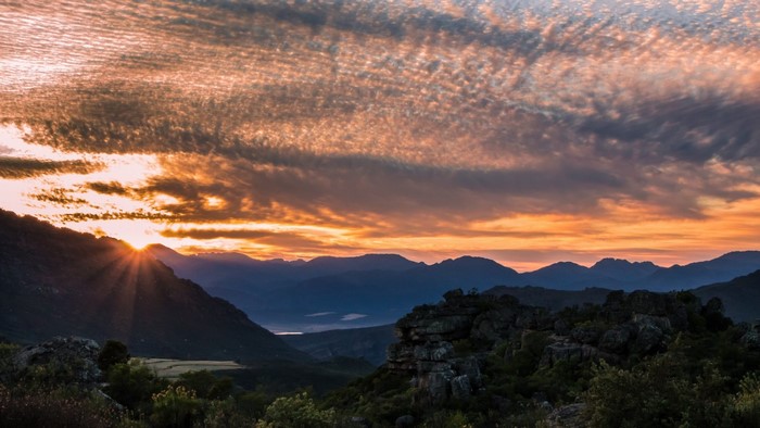 Sunset over a mountain range with dramatic clouds
