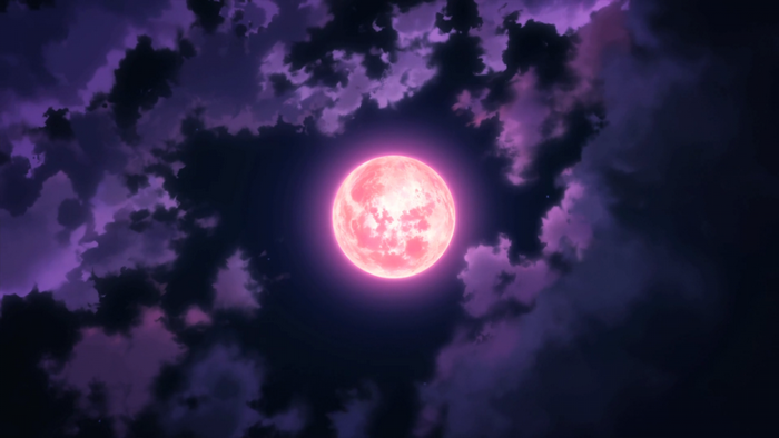 Pink full moon in a cloudy night sky