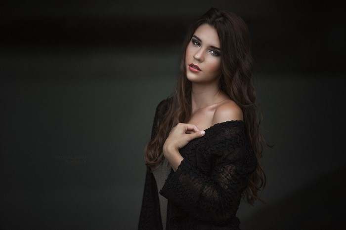 Woman with long brown wavy hair in black lace
