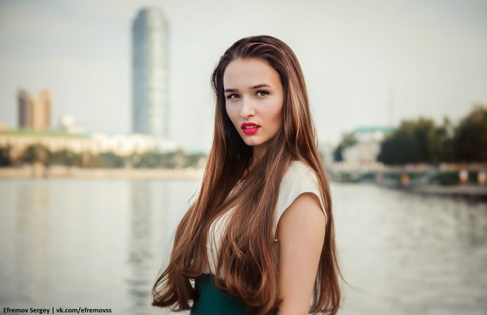 Woman with long brown hair by the water