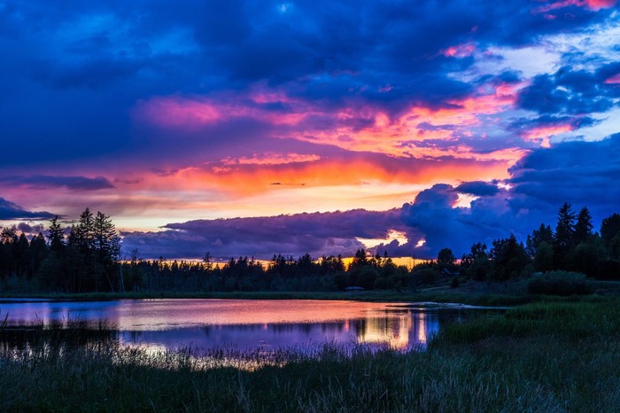 Sunset over a lake with colorful clouds and trees