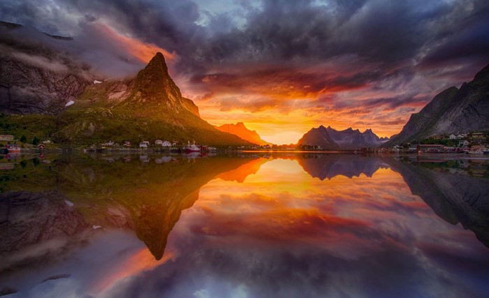Sunset over Lofoten Islands village with mountain reflection