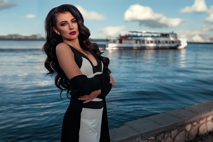 Woman in a black and white dress by the water