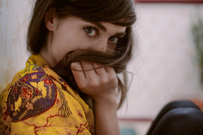 Woman with brown hair covering her face