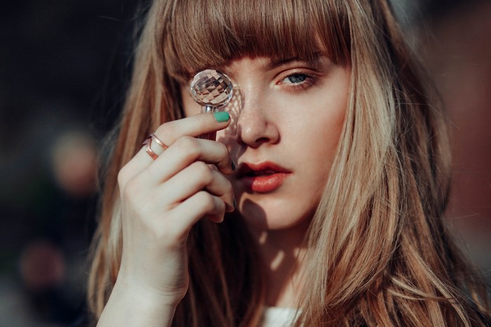 Woman holding a crystal to her eye