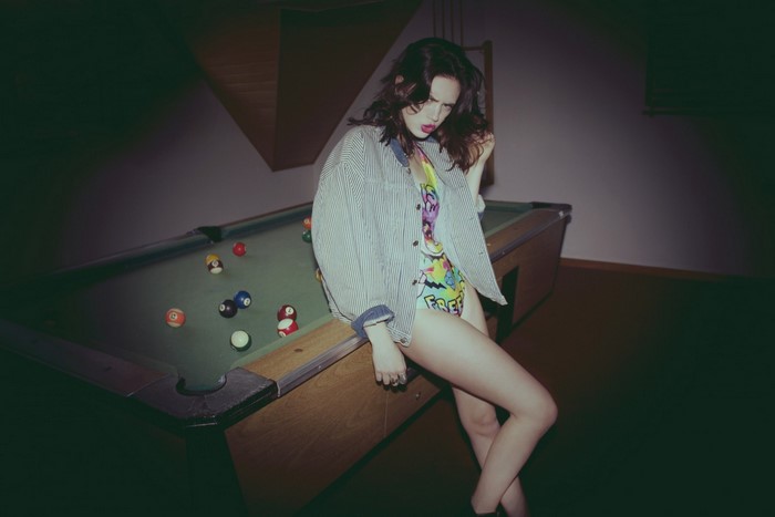 Woman in swimsuit and jacket by pool table