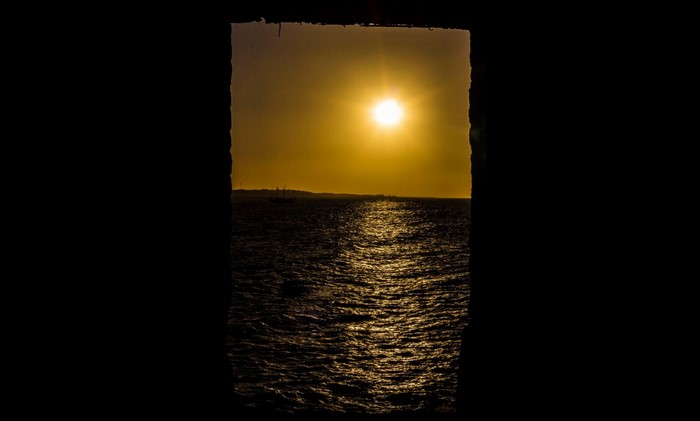 Sunset over the sea with a distant ship