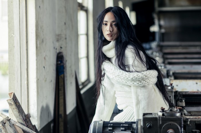 Woman in white sweater in industrial setting