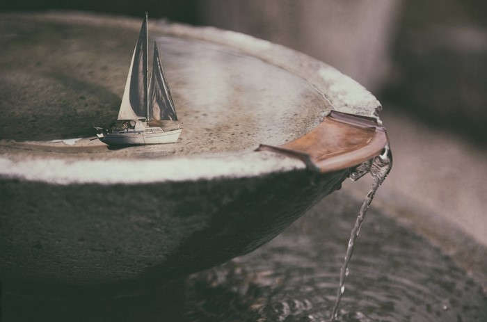 Model sailboat in a fountain with water flowing