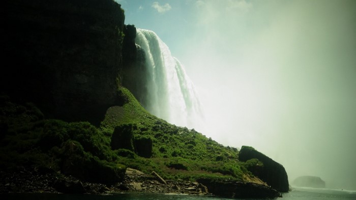 Niagara Falls waterfall with green cliffs and sunlight