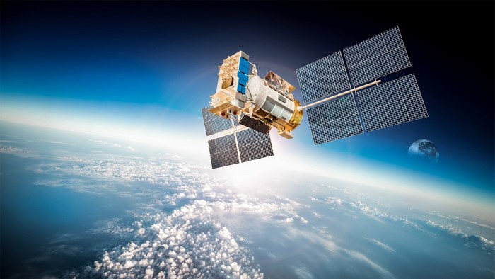 Satellite orbiting Earth with the Moon in the background