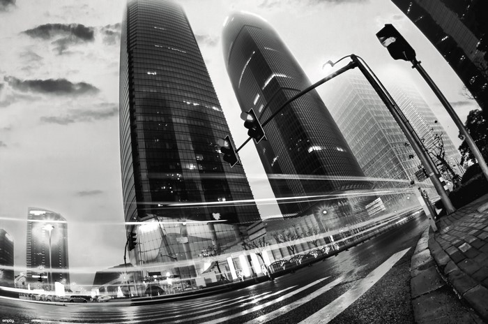 Monochrome cityscape with skyscrapers and light trails