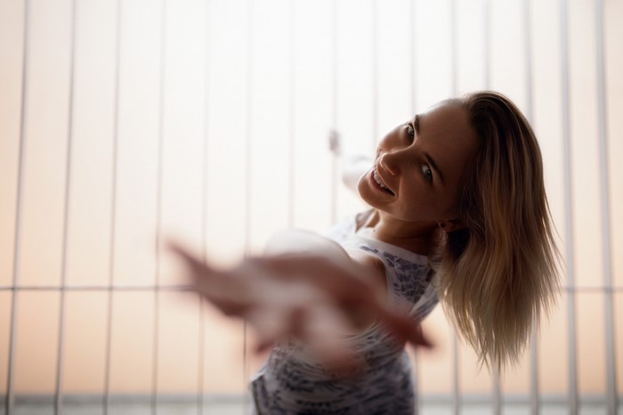 Woman with blonde hair reaching out