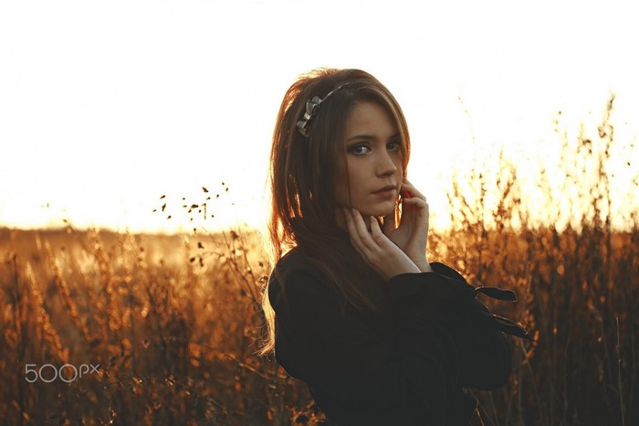 Woman in field at sunset, portrait photography