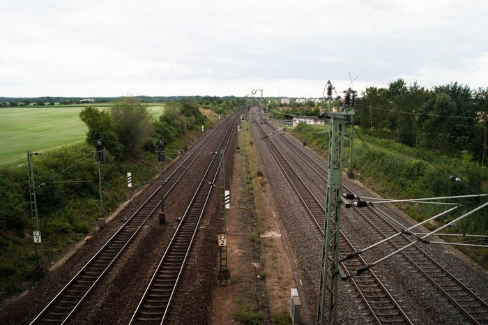 Train tracks through a rural landscape with fields and trees