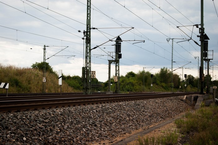 Train tracks with overhead electrical lines and signals