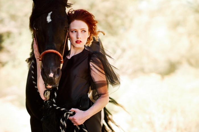 Woman in black dress with a black horse