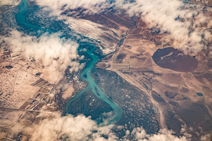 Aerial view of a winding river and lake with clouds