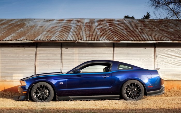 Blue Ford Mustang RTR parked in front of a barn