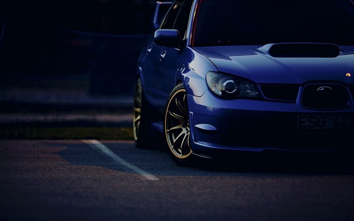 Blue Subaru Impreza WRX STi sports car with gold wheels
