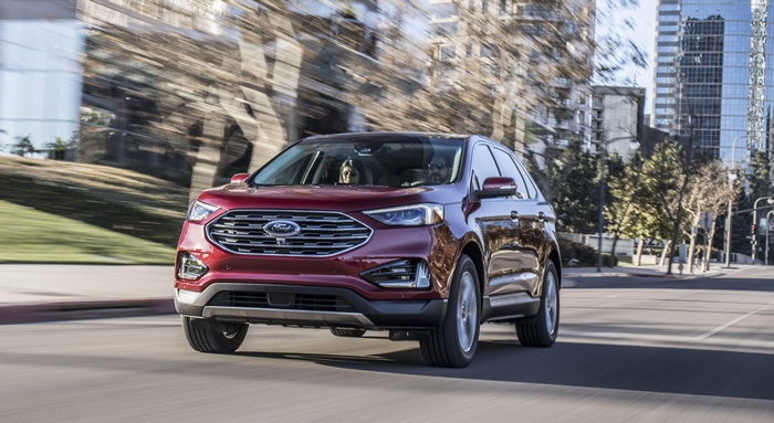 Red Ford Edge driving on a city street