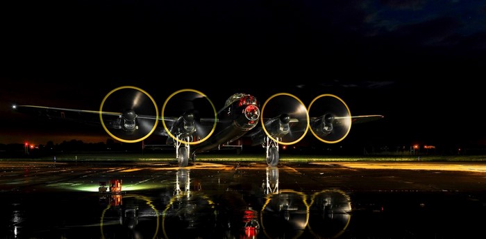 Avro Lancaster bomber on a wet runway at night