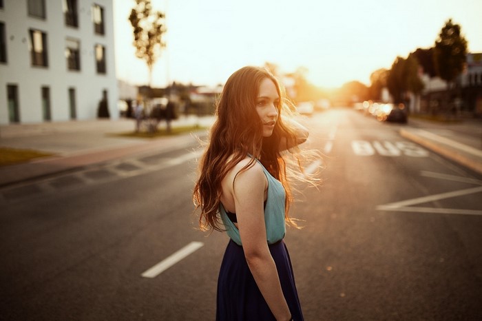 Woman in dress on road at sunset