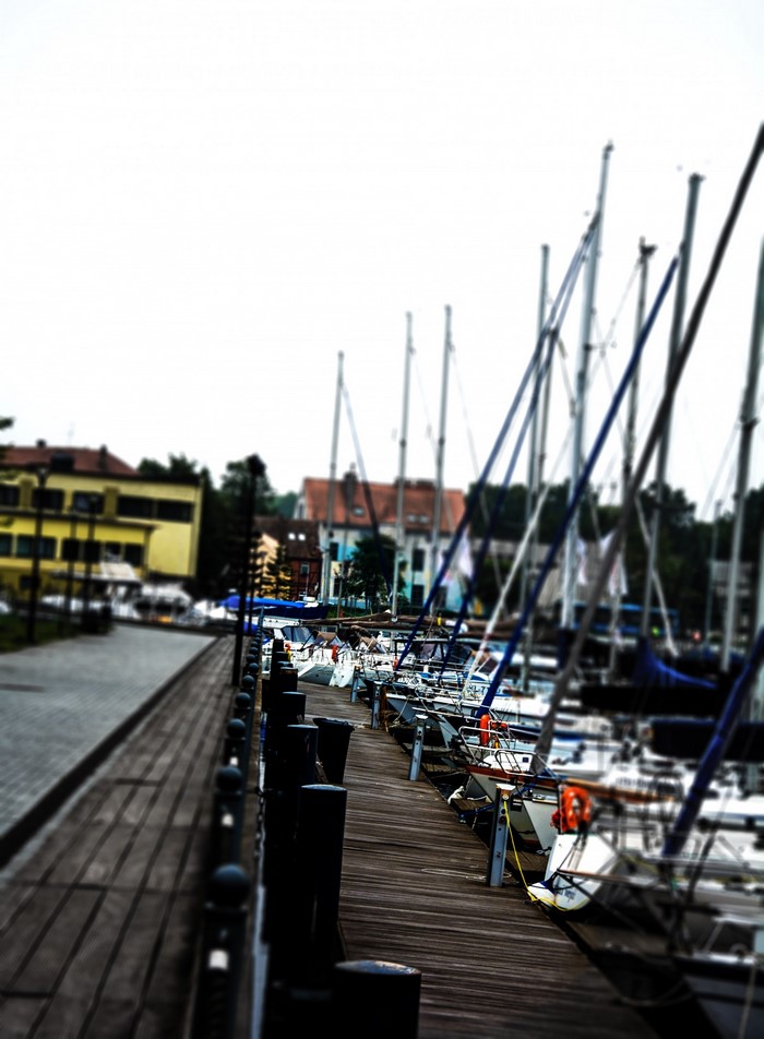 Boats docked at a marina with buildings in the background