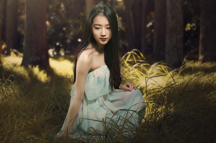 Serene Woman Sitting in Sunlit Forest