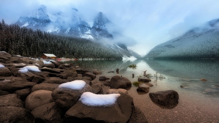 Cabin by a snowy mountain lake in Banff National Park, Alberta