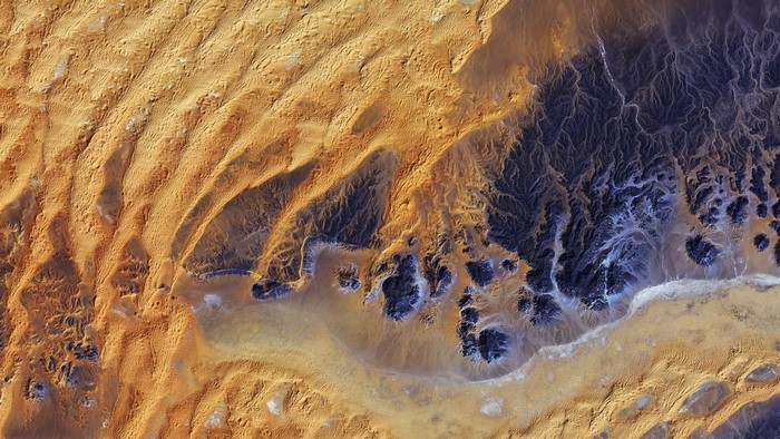 Satellite imagery of desert landscape with sand and rock formations