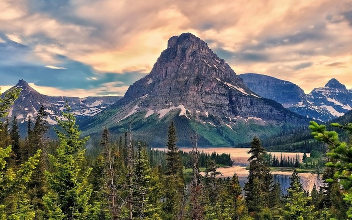 Mountain lake with pine trees and cloudy sky