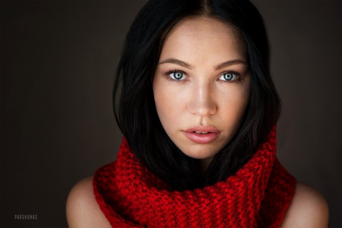 Woman with black hair and blue eyes wearing a red scarf