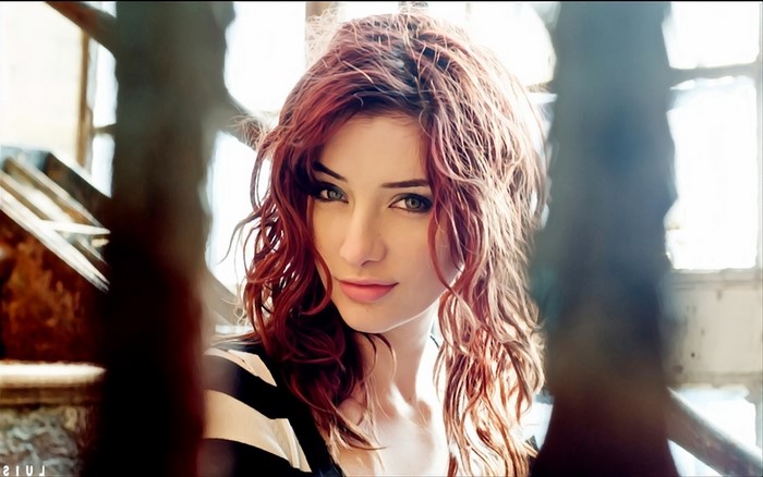 Woman with red curly hair in a striped shirt