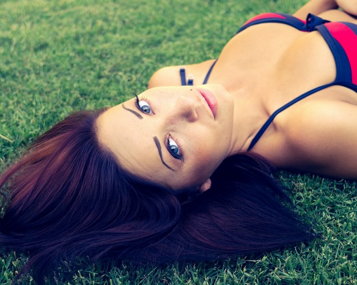 Woman in bikini lying on grass
