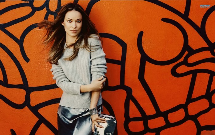 Olivia Wilde posing against a graffiti wall