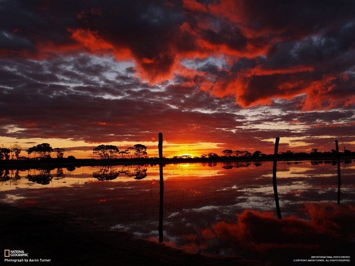 Sunset over water with reflections and clouds