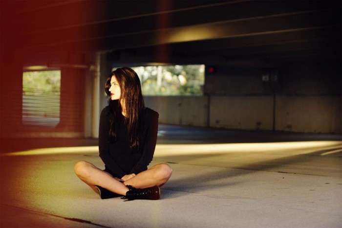 Woman sitting in a parking garage
