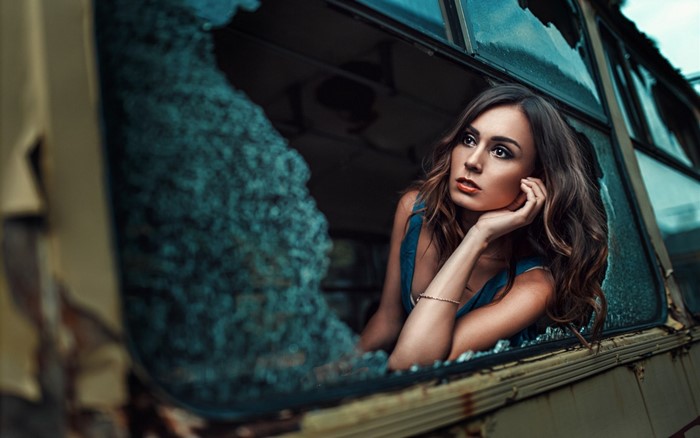 Woman looking out of a broken window