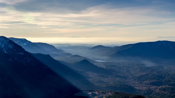 Misty mountain range at sunrise with sunbeams
