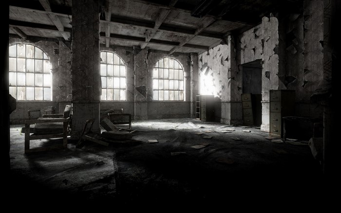 Abandoned room with broken furniture and large windows